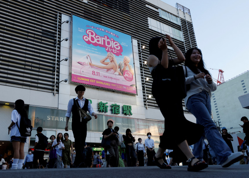 FILE PHOTO: People walk past promotional poster of film "Barbie" in Tokyo